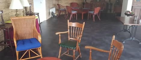 A room with a brick wall, a round table, and multiple chairs.