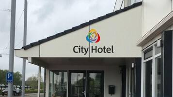 A City Hotel with a modern facade, large windows, and a prominent logo.