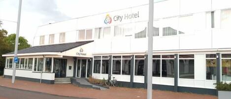A City Hotel building with a white facade, large windows, and a covered entrance.