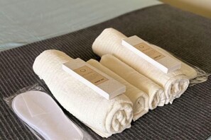 Three neatly folded towels with labels on a textured surface. - Cool Breeze-Serin West Tagaytay 1-bedrooom Condo (Tagaytay)