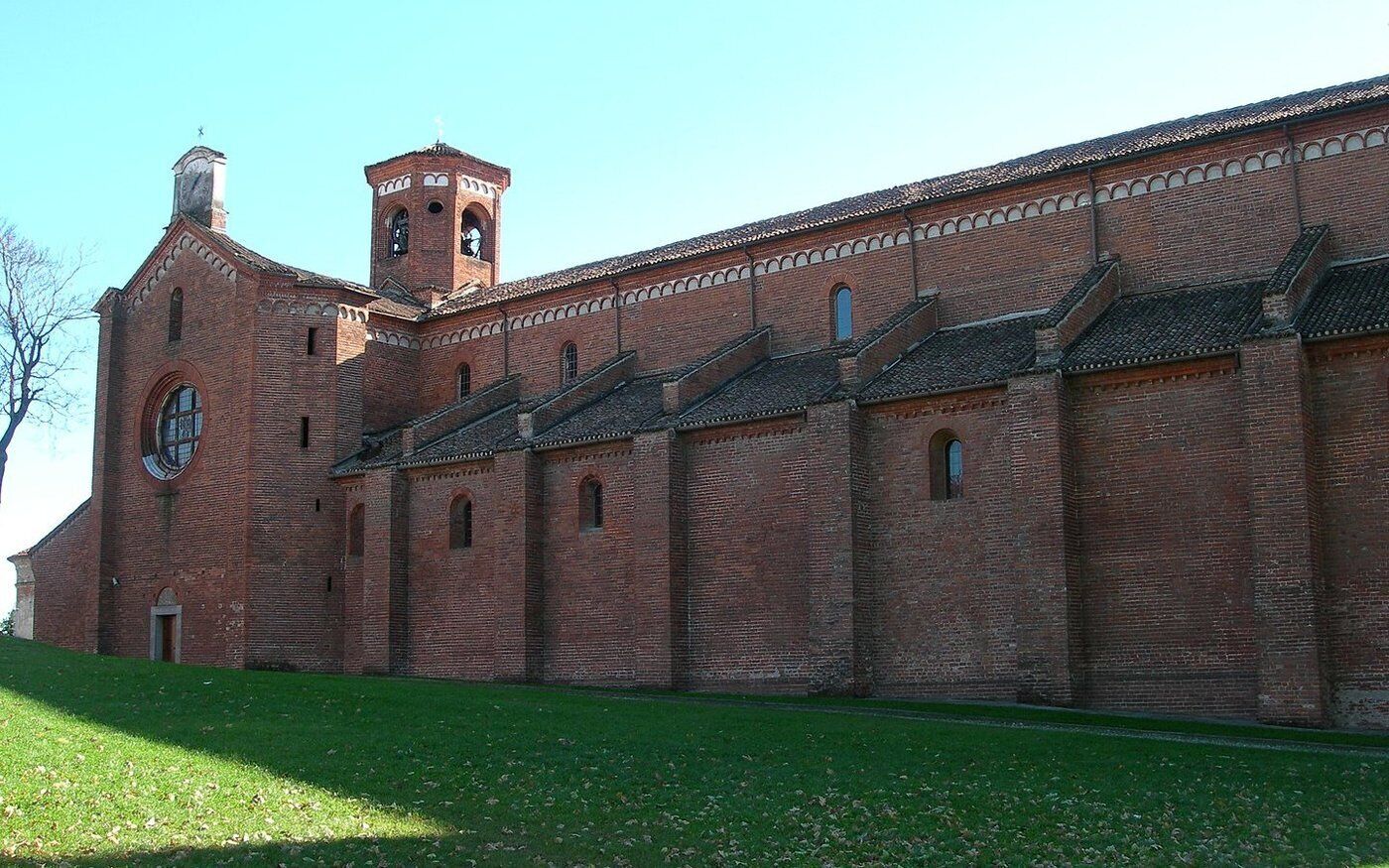 A large brick building with a bell tower and multiple arched windows.