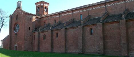 A large brick building with a bell tower and multiple arched windows.