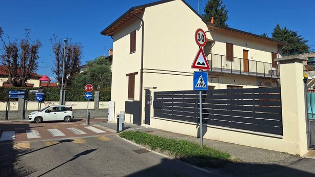 A building with a stop sign, a speed limit sign, and a pedestrian crossing sign. - Kibou Apartment (Garbagnate Milanese)