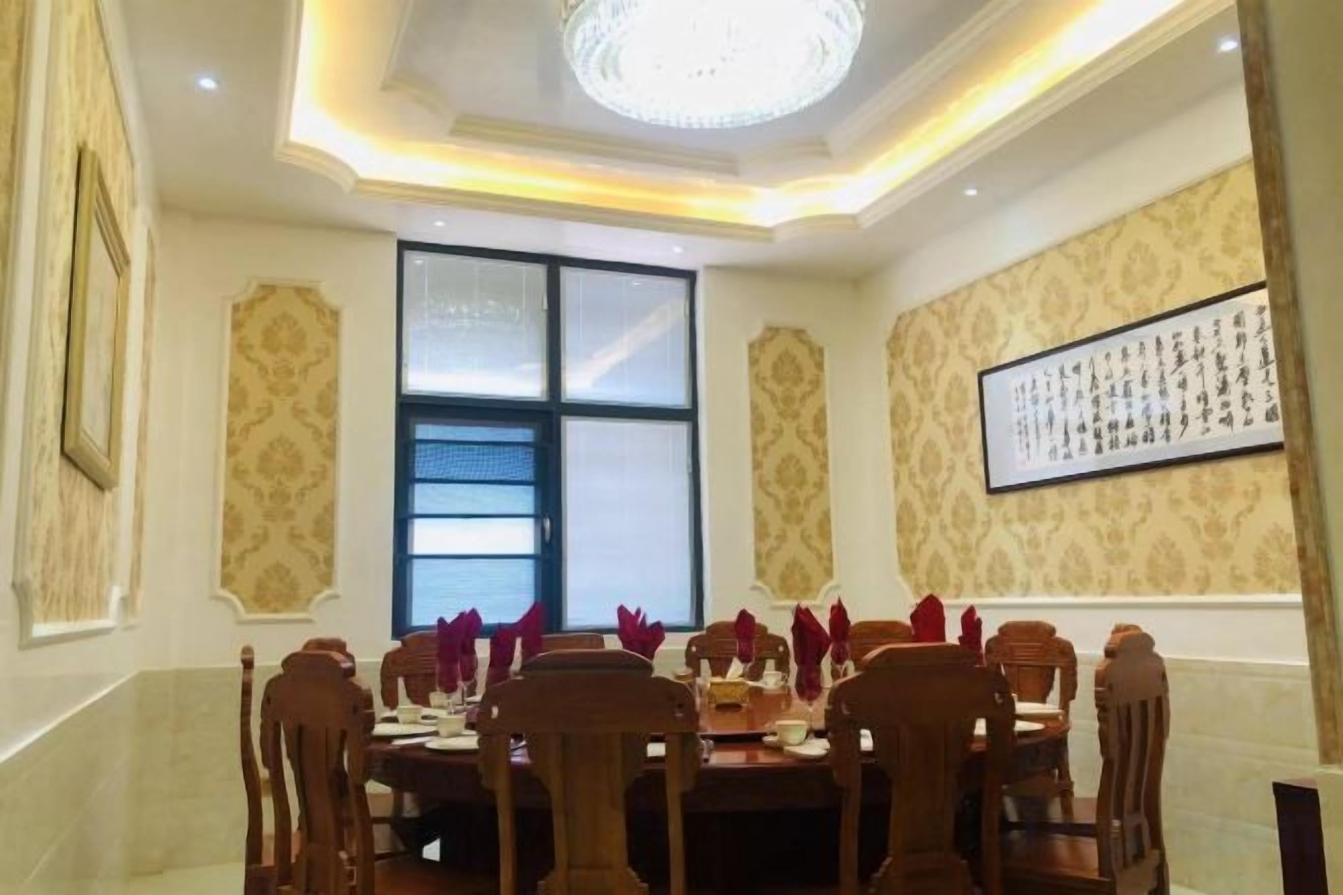 Une salle à manger avec une table ronde, des chaises et un lustre.