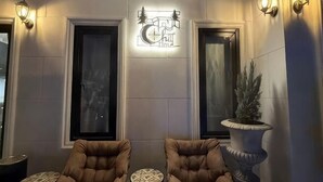 A lobby with two armchairs, a decorative wall sign, and a potted plant. - ChillTime (Chiang Rai)