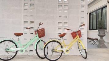 Three bicycles parked in front of a building with a concrete facade.