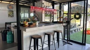 Une cuisine moderne dotée d’un bar, de grandes fenêtres et offrant une vue sur l’extérieur.