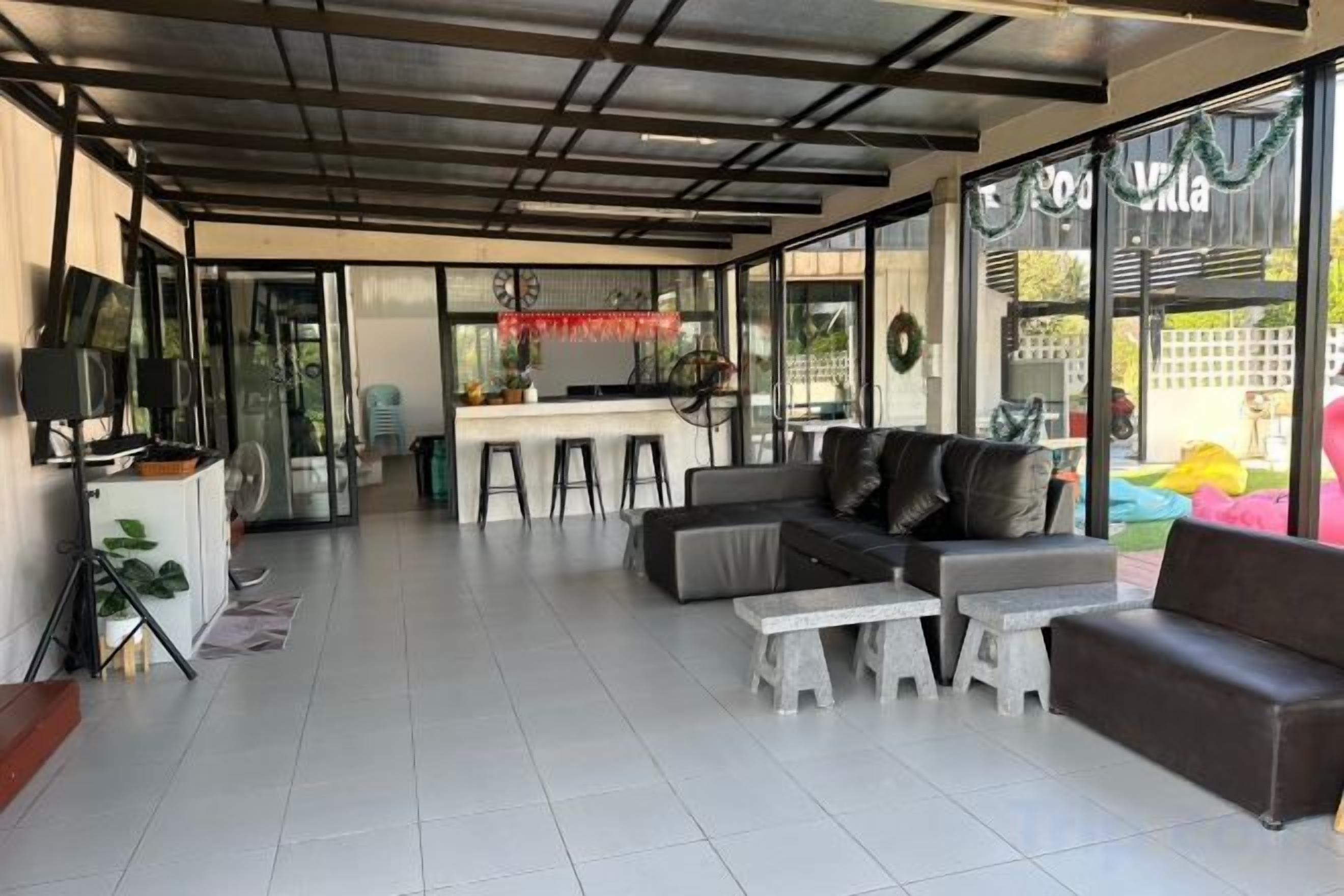 A spacious living area with a sofa, a coffee table, and a bar area in the background.