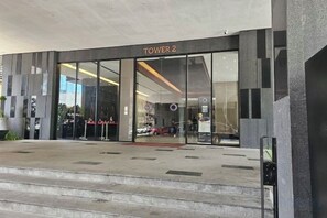 Ein Hotel mit modernem Design, einer Glasfassade und einem Schild mit der Aufschrift 'TOWER 2'.