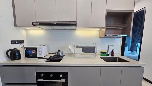 A compact kitchen with a microwave, toaster, kettle, and a small oven. - Opus Residences by Star Haven (Kuala Lumpur)