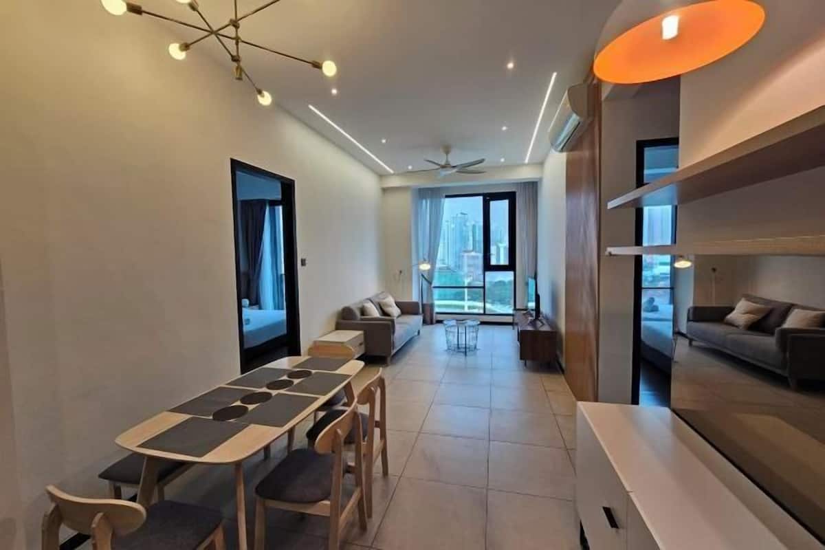 Un salon moderne comprenant un coin repas, un ensemble de canapés et un ventilateur de plafond.