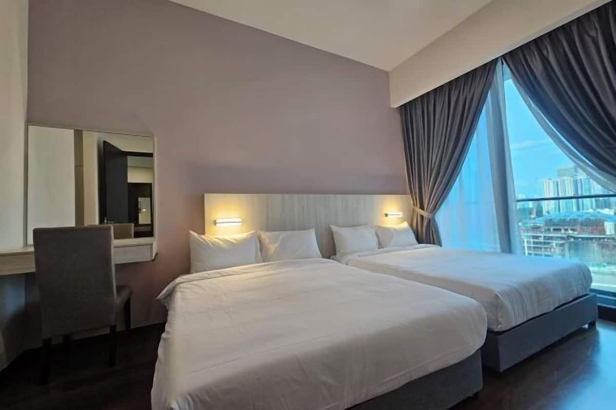 Une chambre d’hôtel avec deux lits, un bureau, une chaise et une grande fenêtre avec des rideaux.