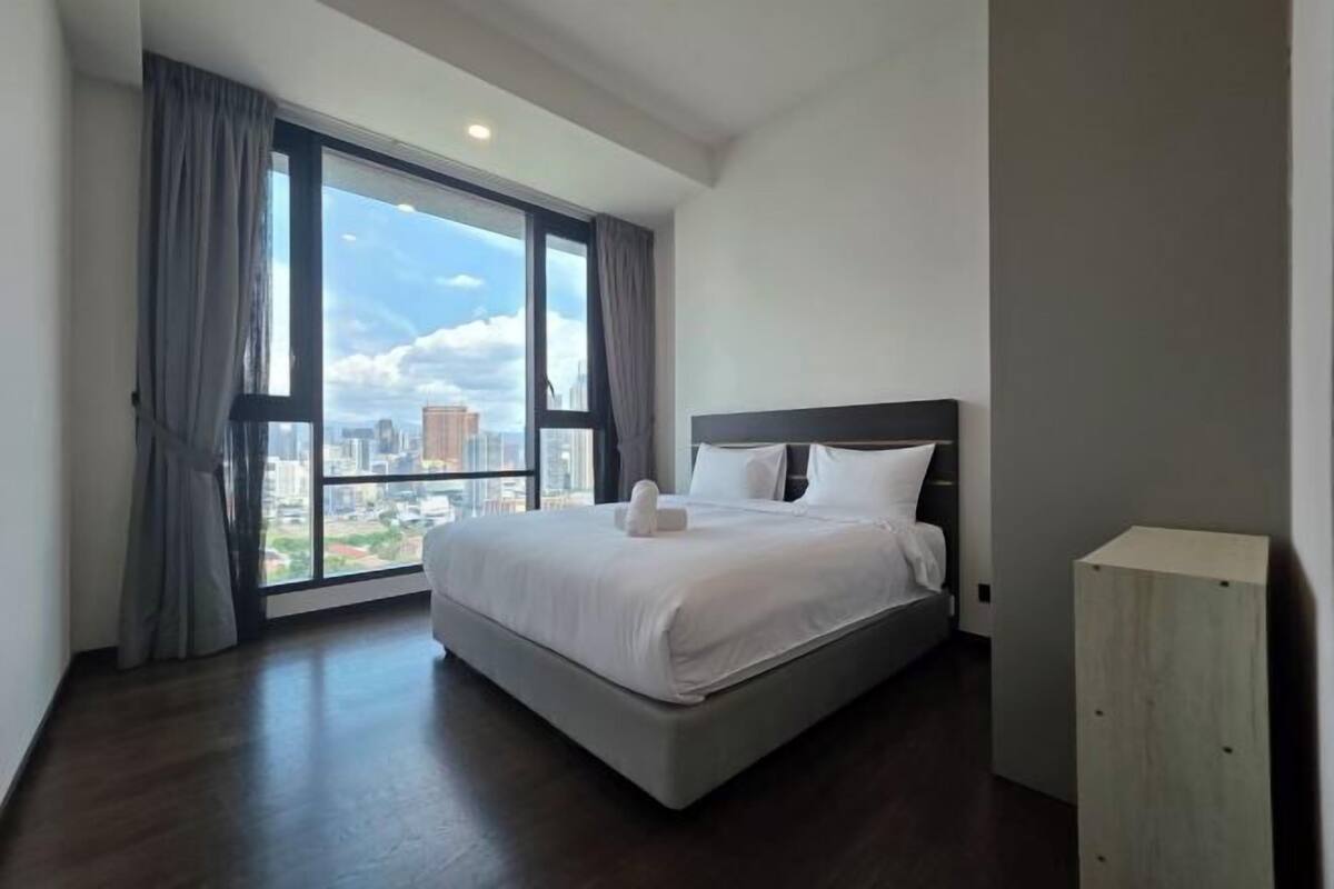 Une chambre d’hôtel moderne avec un grand lit, une vue sur la ville et un plancher en bois.
