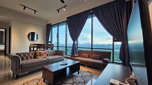 A modern living room with a sofa, a coffee table, and a TV. - Opus Residences by Star Haven (Kuala Lumpur)
