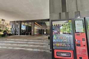 Ein Getränkeautomat mit verschiedenen Getränken und einer Drucktaste.