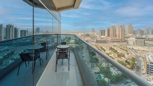 A high-rise building with a glass balcony overlooking a cityscape. - Lux JVT Resort Pools Spa Gym Kids Play (Dubai)
