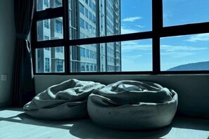 A room with a large window, a bed, and a view of a building. - Jesslton quay Dream stay (Kota Kinabalu)