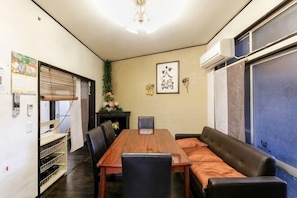 A dining area with a wooden table, black chairs, and a brown sofa.