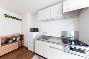 Een moderne keuken met witte kasten, een roestvrijstalen fornuis en een magnetron.