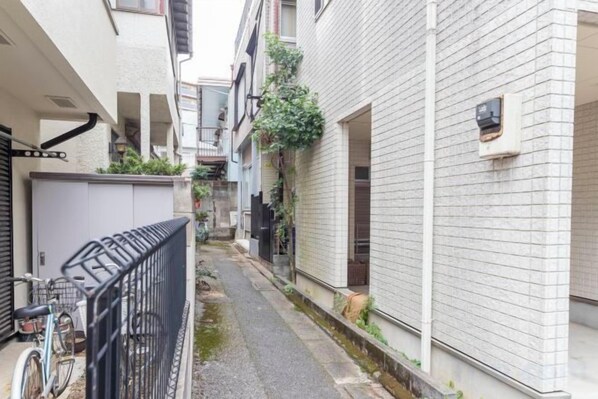 A narrow alleyway between buildings with a bicycle parked on the left.