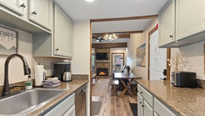 A modern kitchen with granite countertops, stainless steel appliances, and a central island. - The Retreat #6 (Breckenridge)