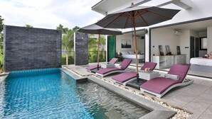 Zona de piscina exterior moderna amb gandules i ombrel·les.