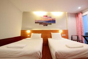 A hotel room with two beds, a wooden headboard, a wall-mounted artwork, and a window with curtains. - Collection O Thaiphiphat House Silom (Bangkok)