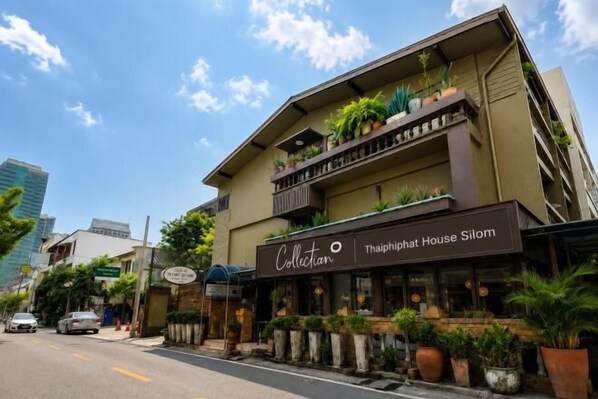 Un edificio de varios pisos con un letrero que dice 'Collection Thaiphaphat House Silom'.