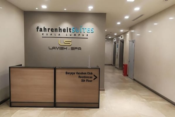A hotel reception desk with a sign for Fahrenheit Suites Kuala Lumpur and Lavish Spa. - Fahrenheit 88 Suites Bukit Bintang by Roseline (Kuala Lumpur)