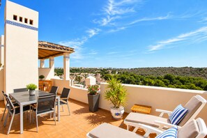 A terrace with a table and chairs, a sun lounger, and a view of a hillside. - New listing! Stunning penthouse with views, large terraces, close to everything (VC)