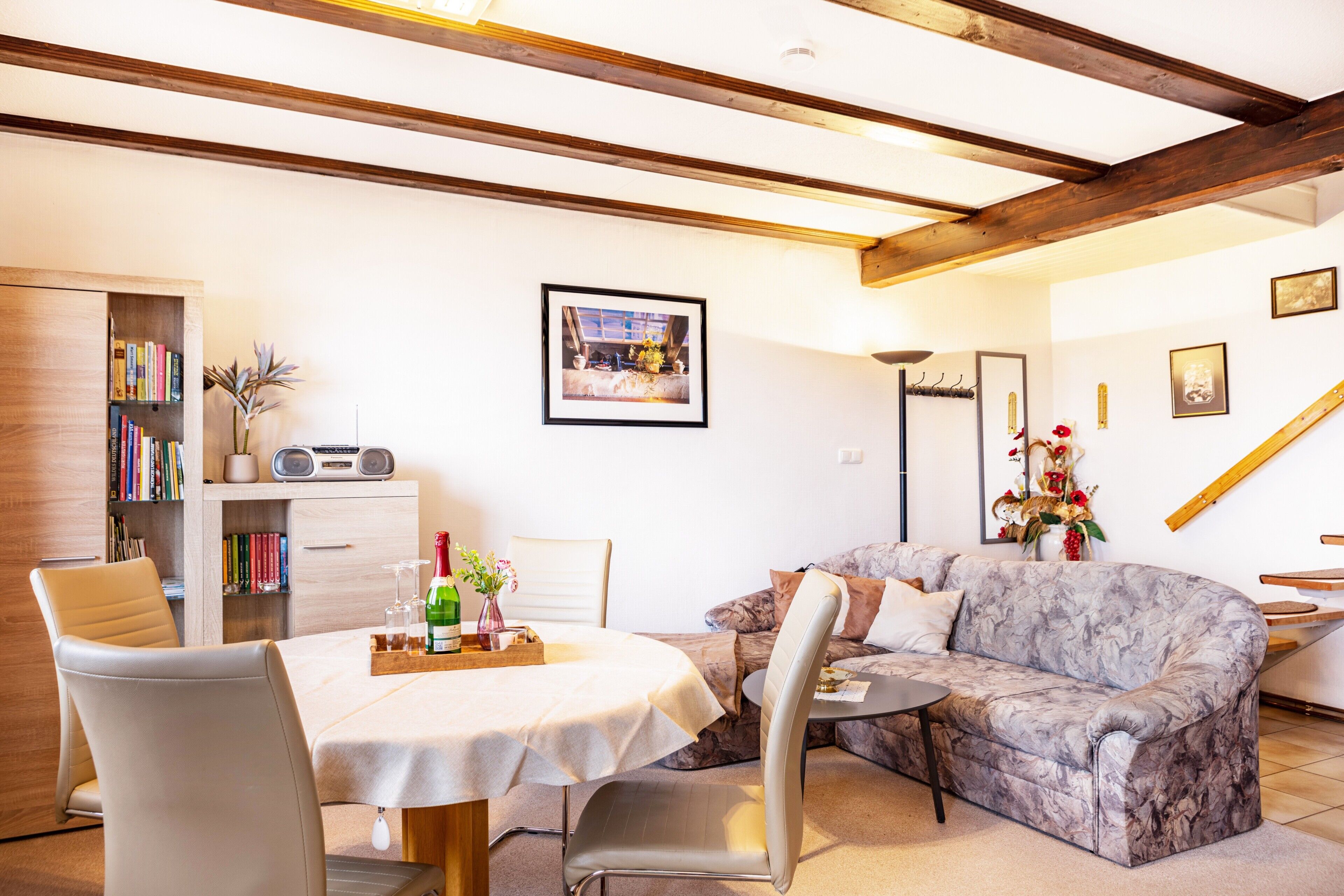 A living room with a dining table, sofa, and bookshelf.
