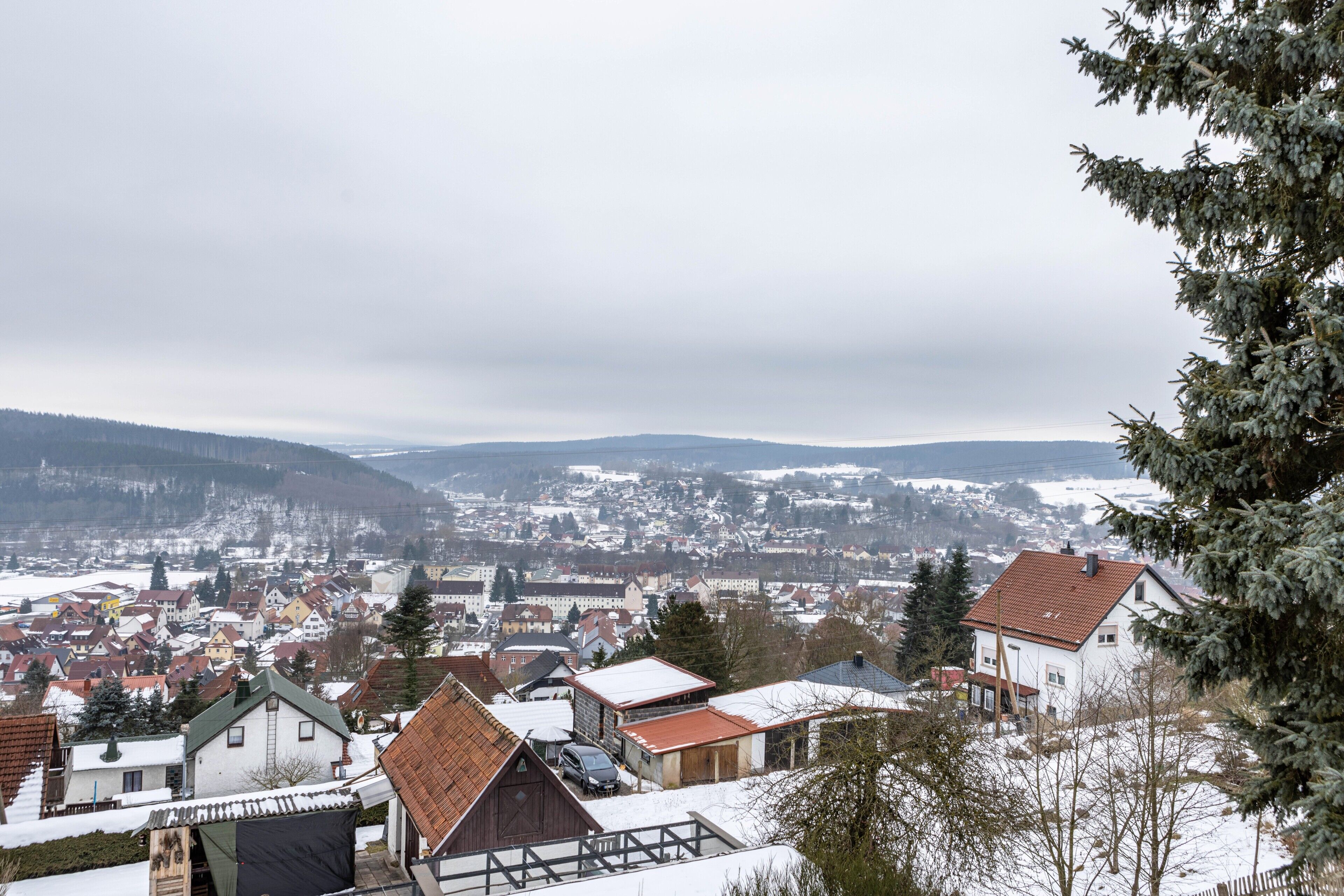 A town with snow-covered buildings and a view of distant hills.