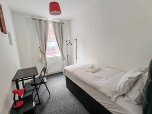 A small, clean room with a bed, a desk, and a chair. - Central Wolverhampton Stay (Wolverhampton)