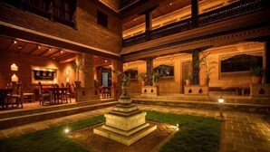 A courtyard with a fountain, seating area, and a bar. - Nagpukhu Guest House (Bhaktapur)