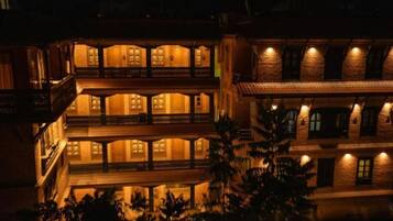 A multi-story building with balconies and warm lighting.