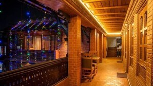 A cozy interior with brick walls, wooden beams, and a tiled floor. - Nagpukhu Guest House (Bhaktapur)