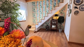 A wooden staircase with floral wallpaper, a woven mat, and a wall with decorative plates. - Agroturismo Quinta Vale Salgueiro - Aurora family house - Serra da Estrela (Carragozela)