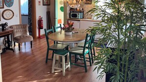 A dining area with a wooden table and chairs, a chandelier, and a potted plant. - Agroturismo Quinta Vale Salgueiro - Aurora family house - Serra da Estrela (Carragozela)