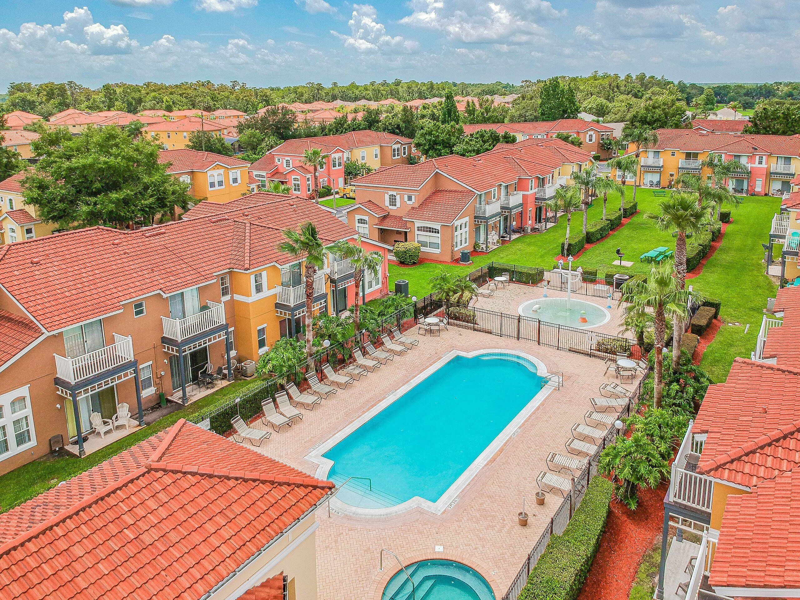 A residential area with houses, a swimming pool, and a fountain.