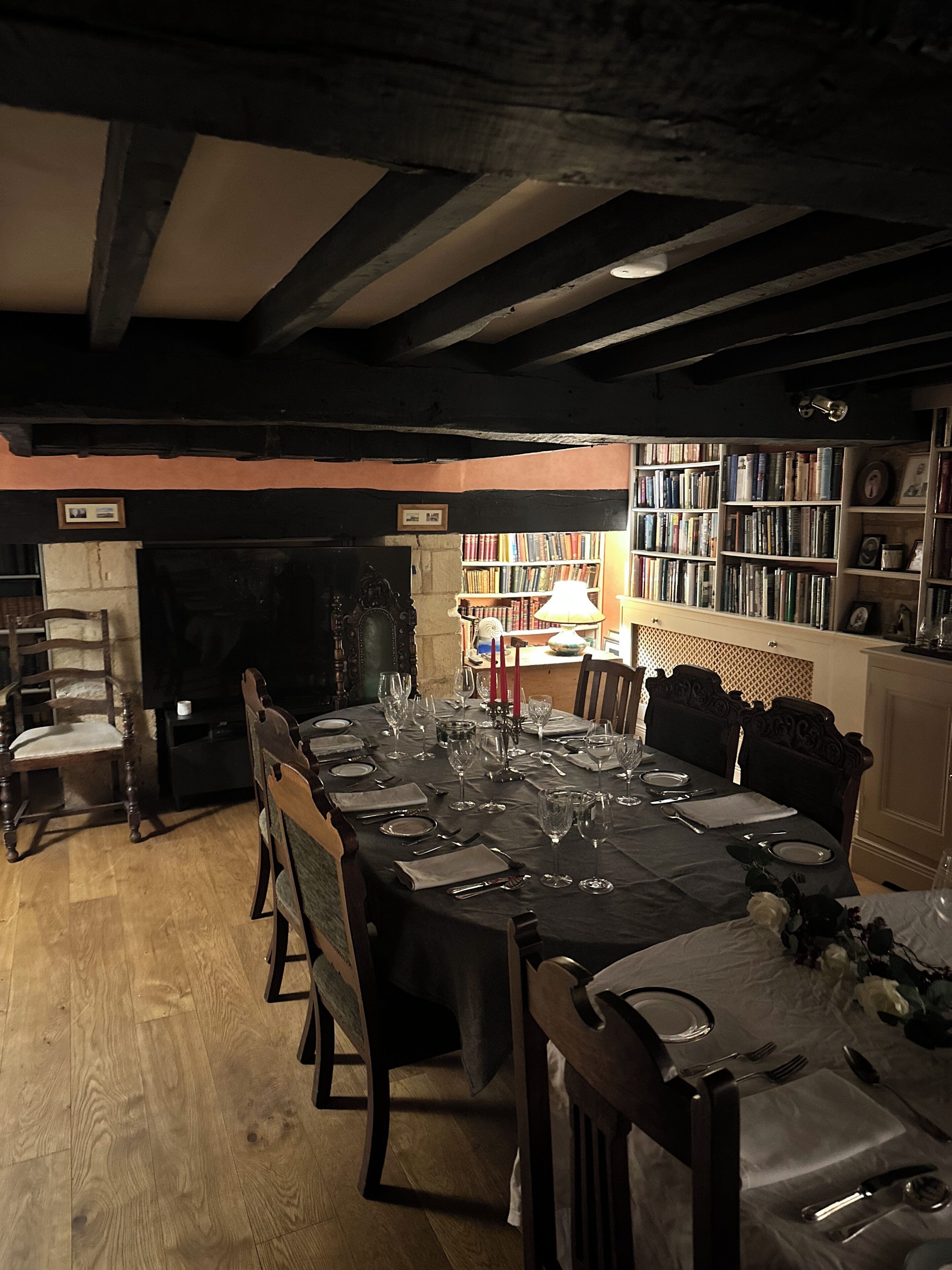 A dining area with a long table set for a meal, surrounded by chairs.