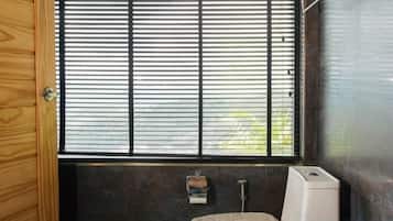 Un baño con ventana, una toalla y un inodoro.
