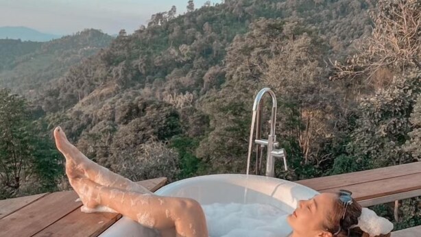 A person relaxing in a hot tub with a mountainous landscape in the background. - Sinsup villa private Mountain View (Mae Suai)