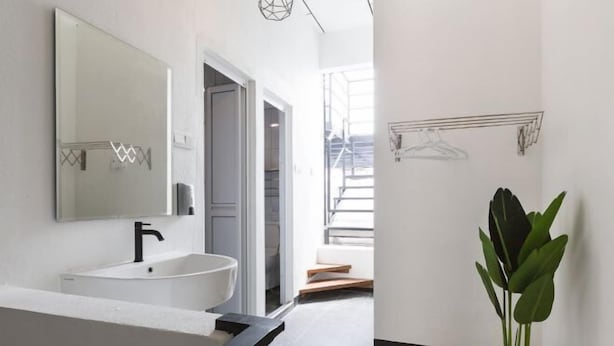 A modern bathroom with a large mirror, a white sink, and a potted plant. - 7-Room Exec House, Rumahku Express, Georgetown (George Town)