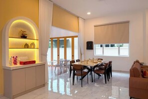 Un espace repas moderne avec un sol en marbre, une table centrale et des chaises.