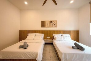 A hotel room with two beds, wooden headboards, white bedding, and a marble floor.