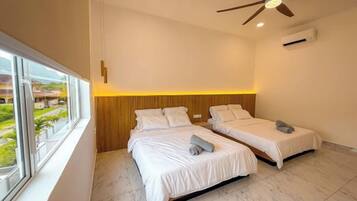 A bedroom with two beds, a ceiling fan, and a window with a view.