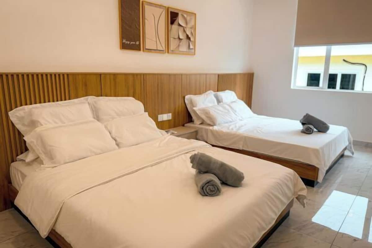 Ein Hotelzimmer mit zwei Betten, einem hölzernen Kopfteil und Bildern an der Wand.