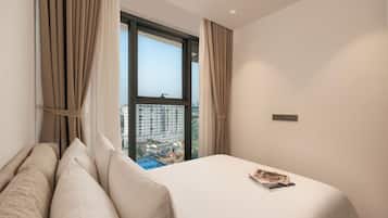 A hotel room with a large window, a bed with white linens, and a view of a cityscape.