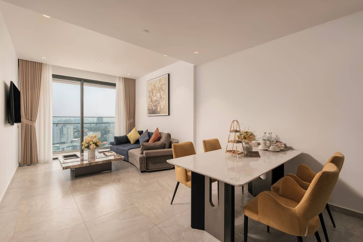 Una sala de estar moderna con comedor, ventanas grandes y vista a la ciudad.