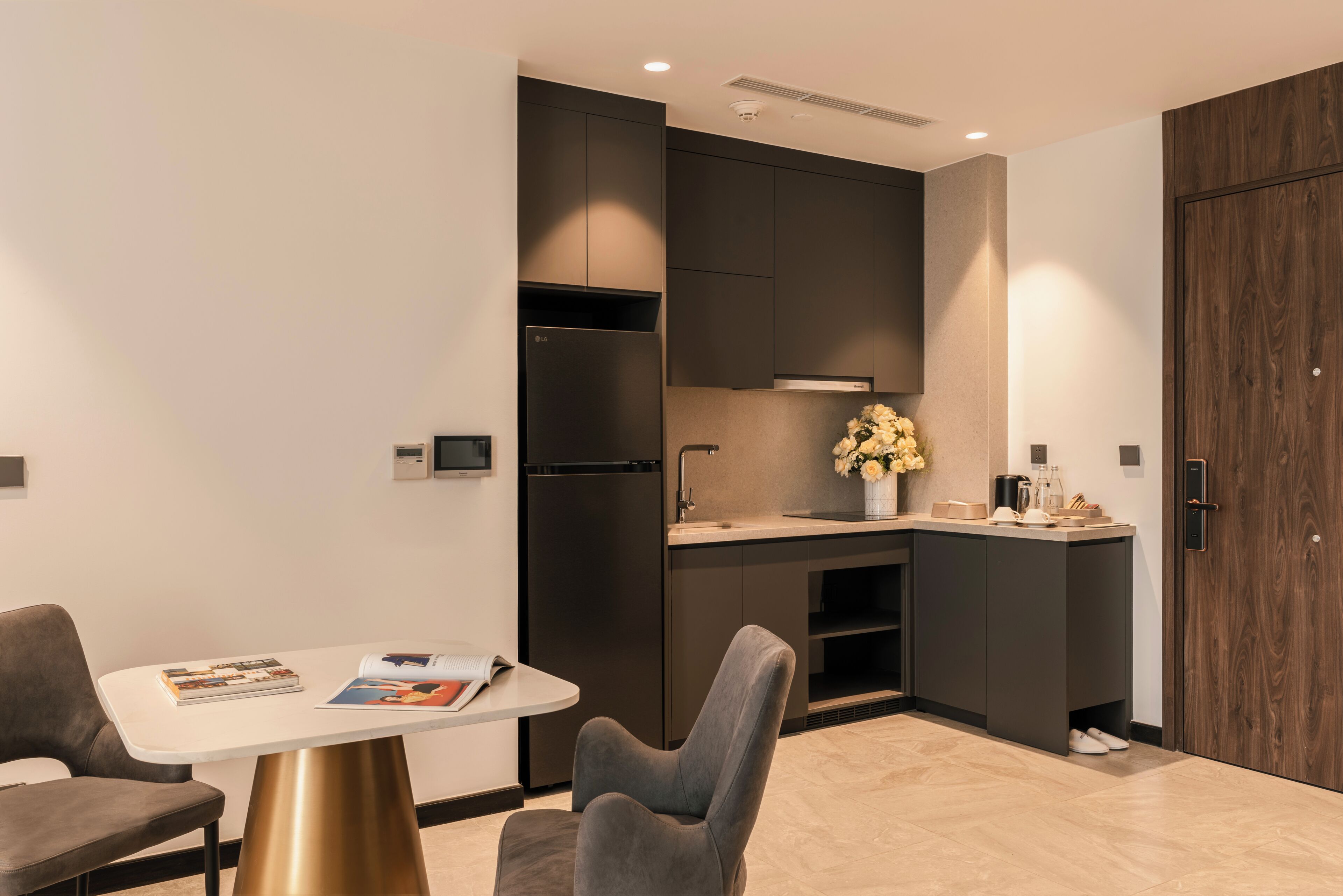 A modern kitchen with dark cabinetry, a white countertop, and a built-in oven.